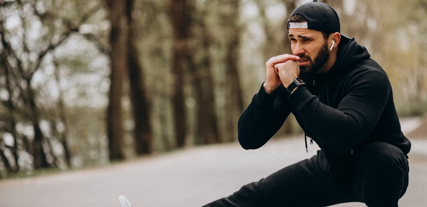 Focused athlete in a black hoodie outdoors, representing sports physical therapy and recovery in Parker, TX.