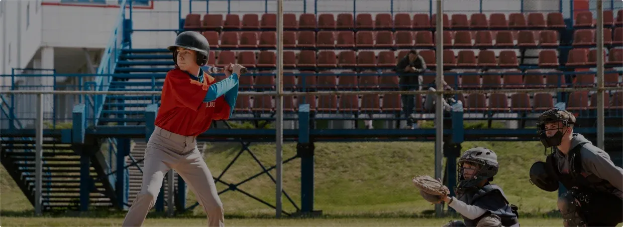 Youth baseball player in a batting stance during a return-to-throwing program.