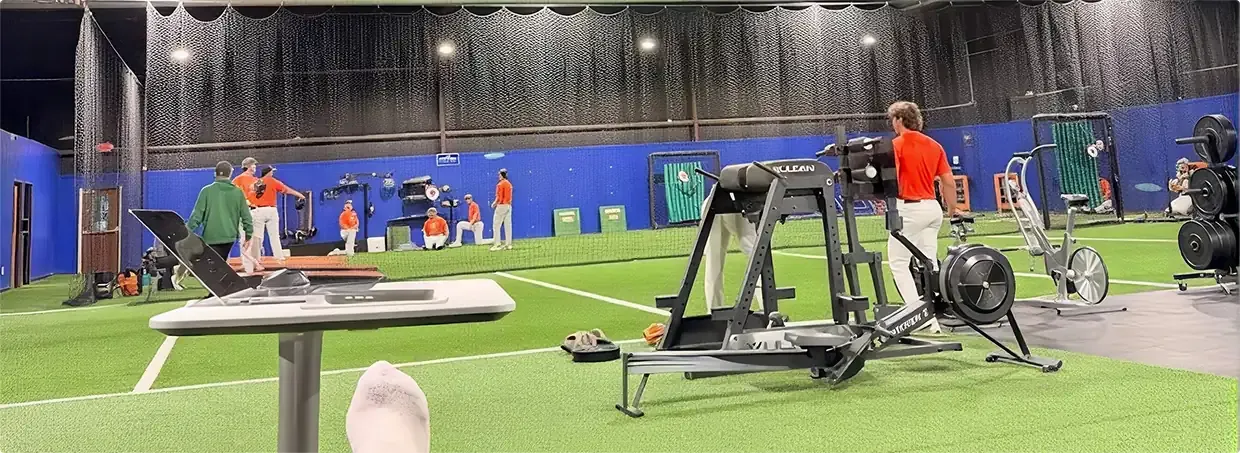 Indoor sports training facility with turf flooring and fitness equipment for sports physical therapy rehab and performance training.