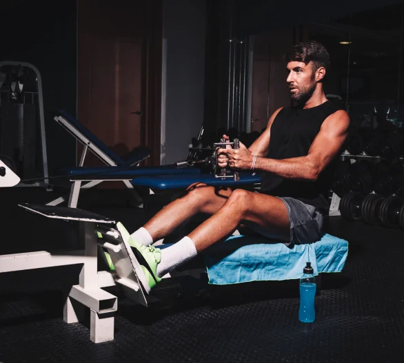 Athlete using gym equipment for strength training during sports rehab session.