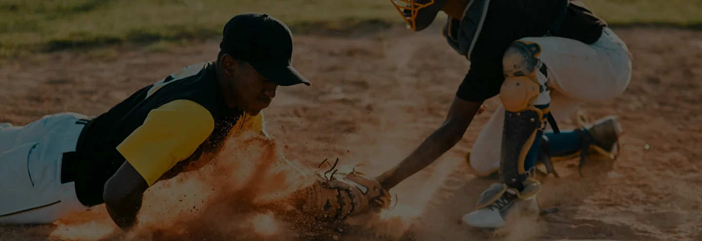 Baseball player crouching on a dirt field.