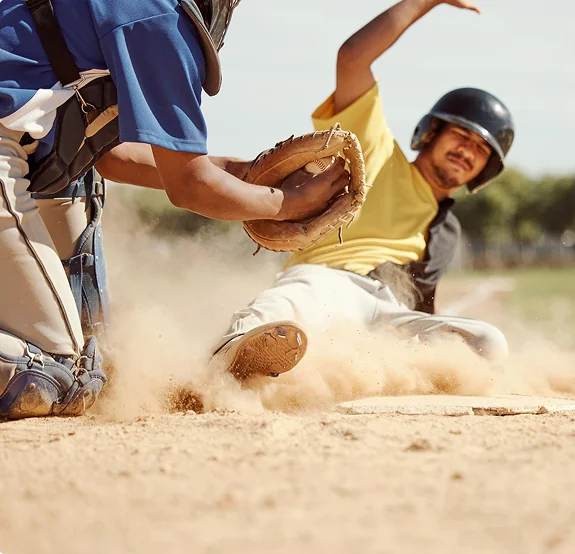 Baseball runner sliding into home plate.