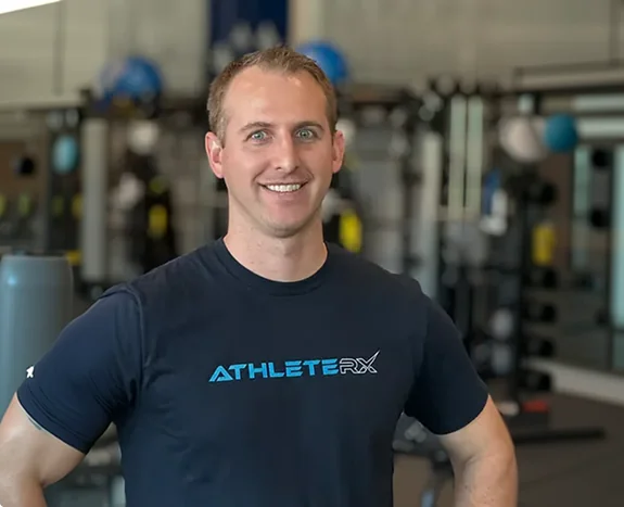 Therapist assessing an athlete's knee in the AthleteRx clinic